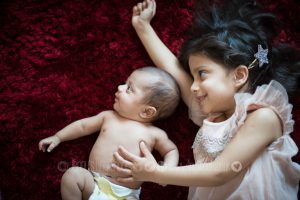 portrait of newborn and sister at home