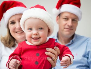 Baby in Santa outfit with family