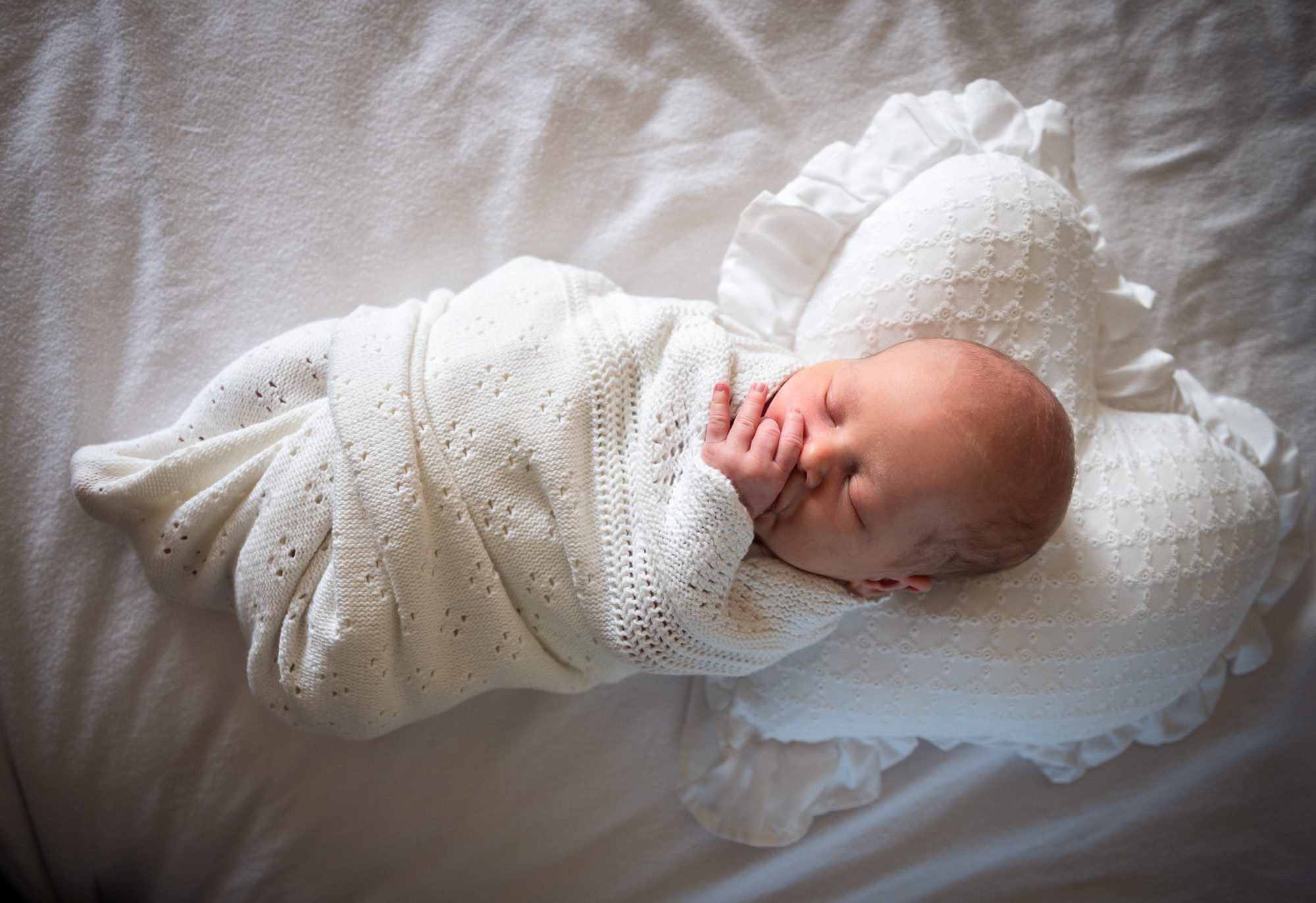 Newborn baby photo wrapped in white blanket