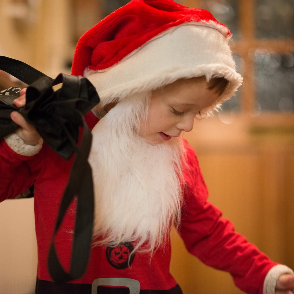 Boy dressed as santa with a sack