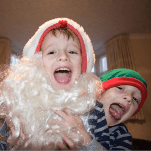 Boy dressed as santa with big grin