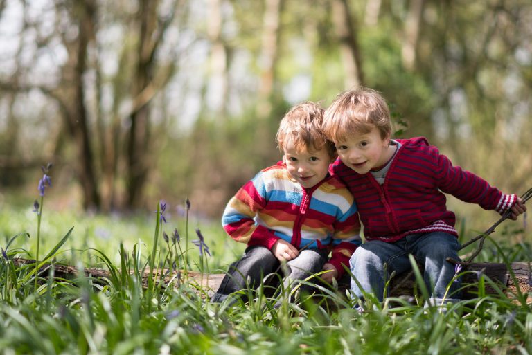 Twins on a log in the woodland portrait