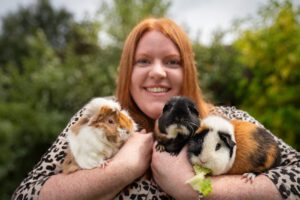 Woman cuddling her 3 guinea pigs