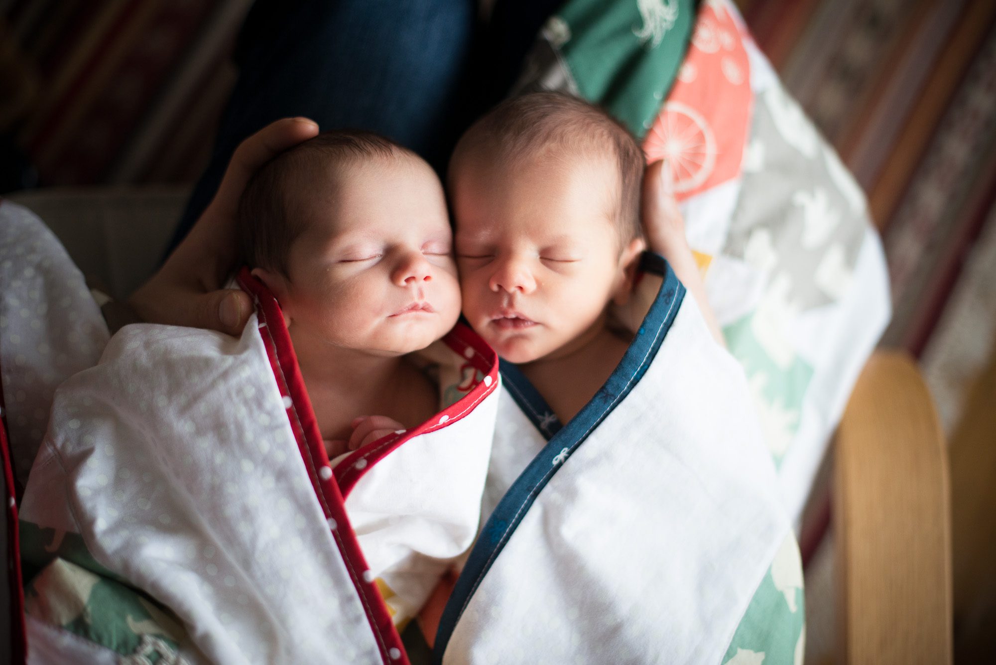 Newborn twins wrapped in handmade blankets