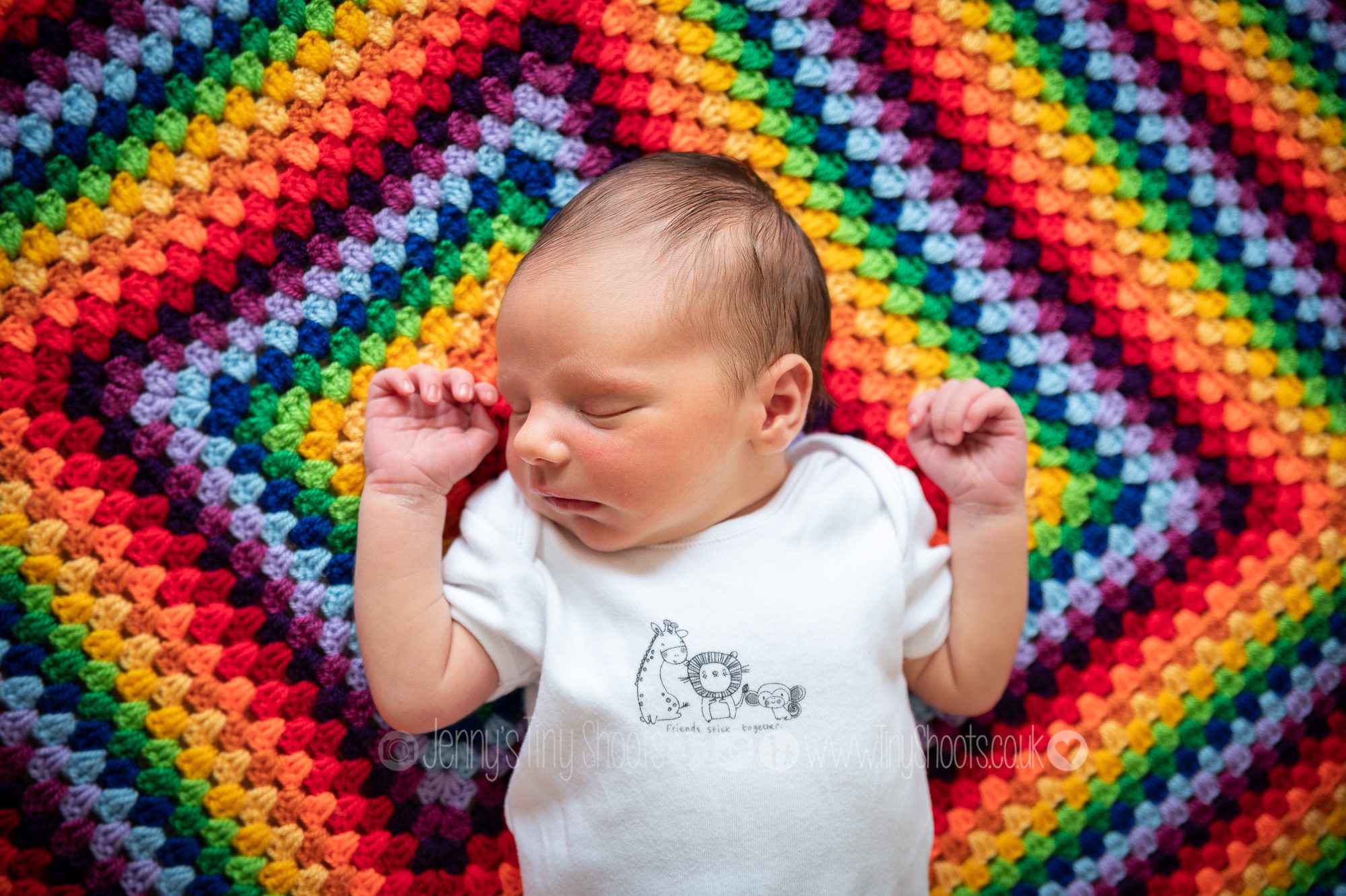 Natural newborn portrait on rainbow blanket