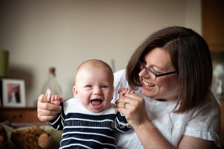 smiling 6 month old baby boy with mum