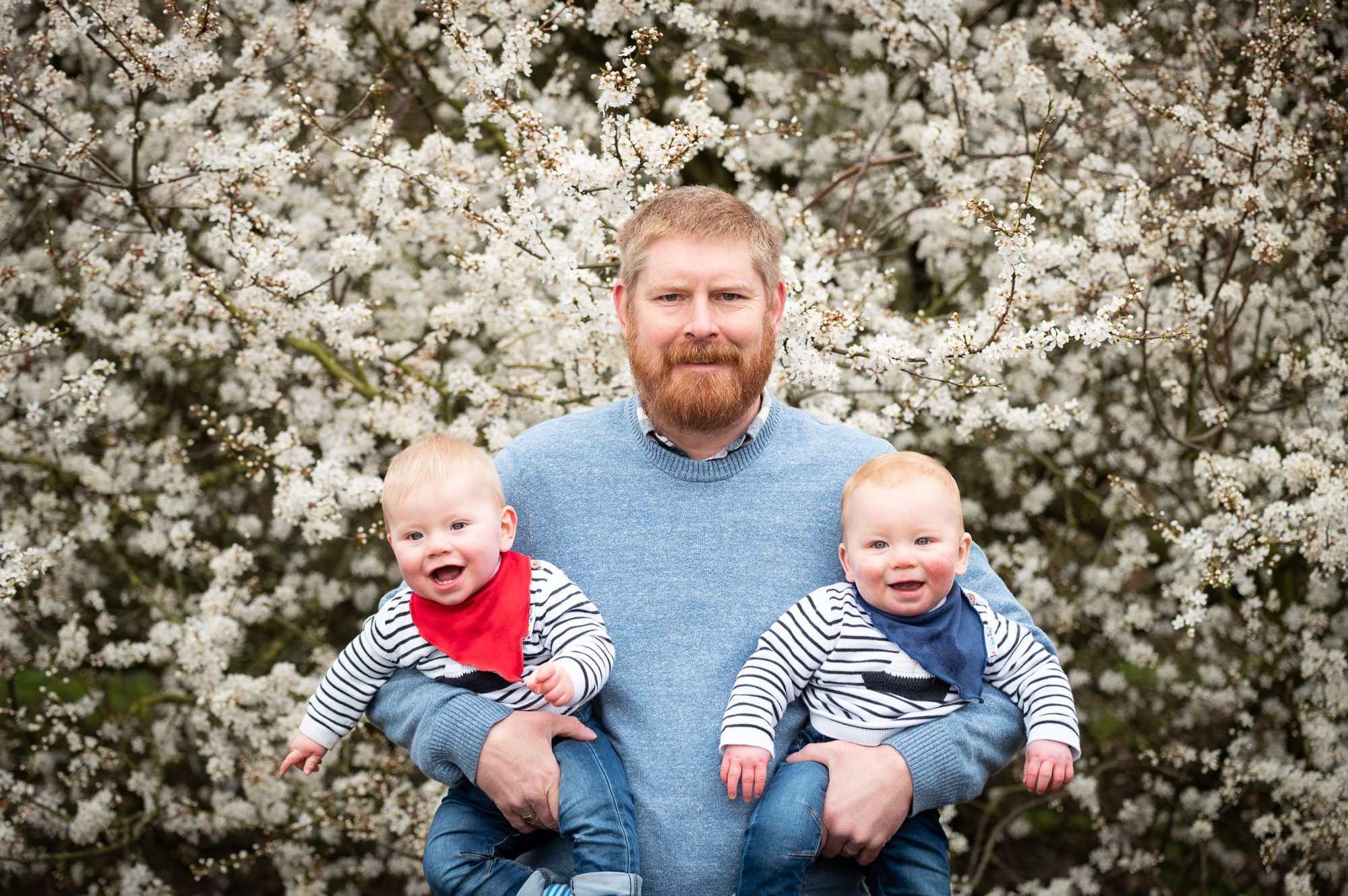 Baby twins being held by dad