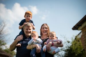 family in the garden at home with baby twins and toddler