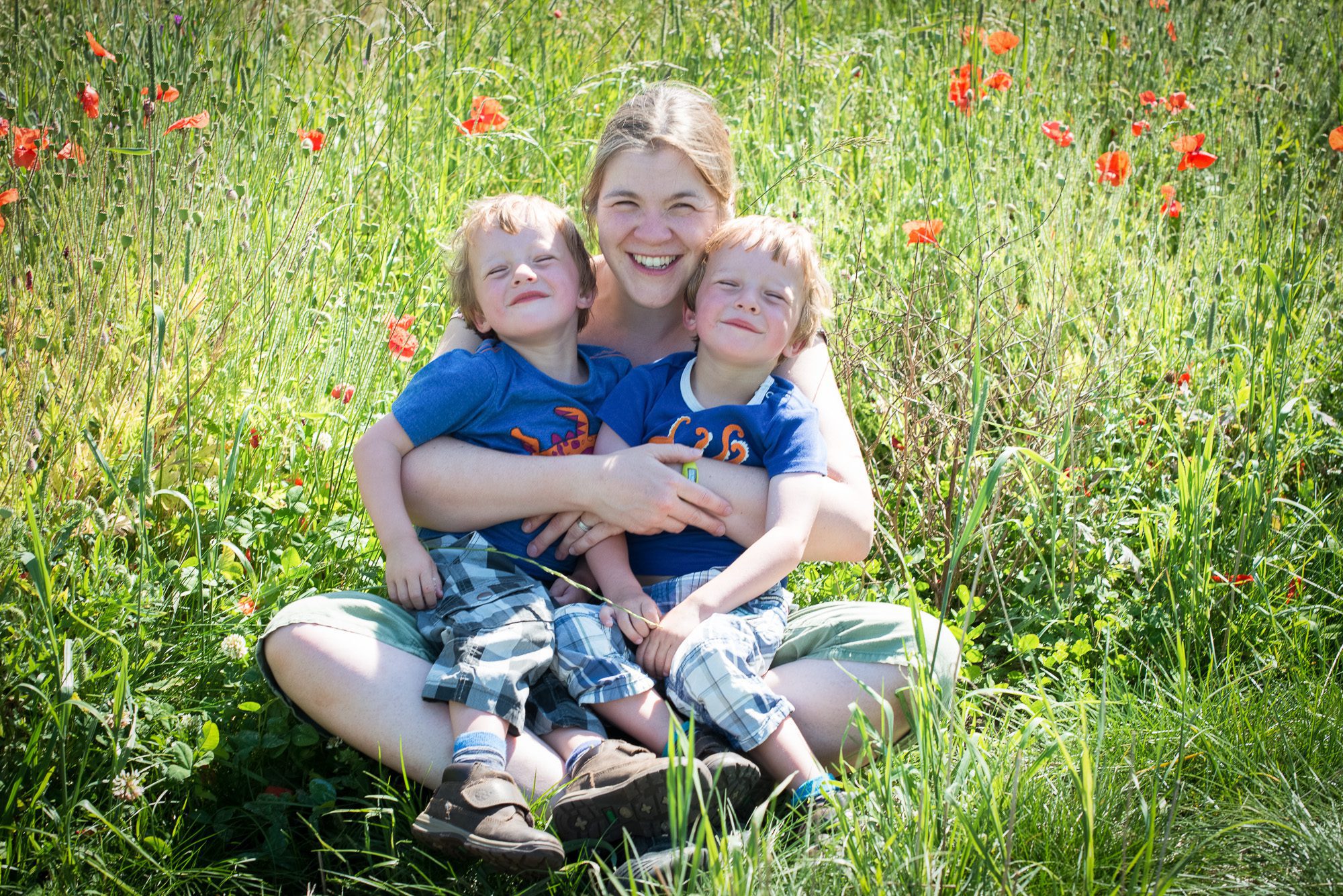 mother and twins portrait in poppy field
