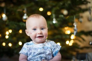 Baby girl portrait at home with christmas tree