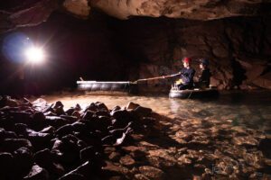 two boys in a boat in a lake in a mine cave photography