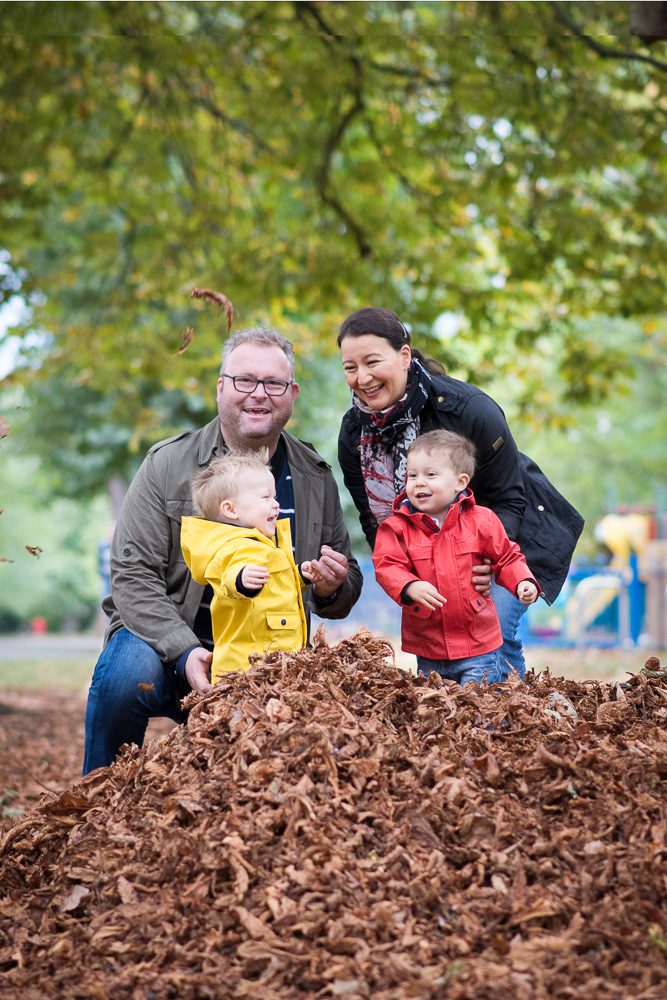 family photography Twin boys playing in leaves in london