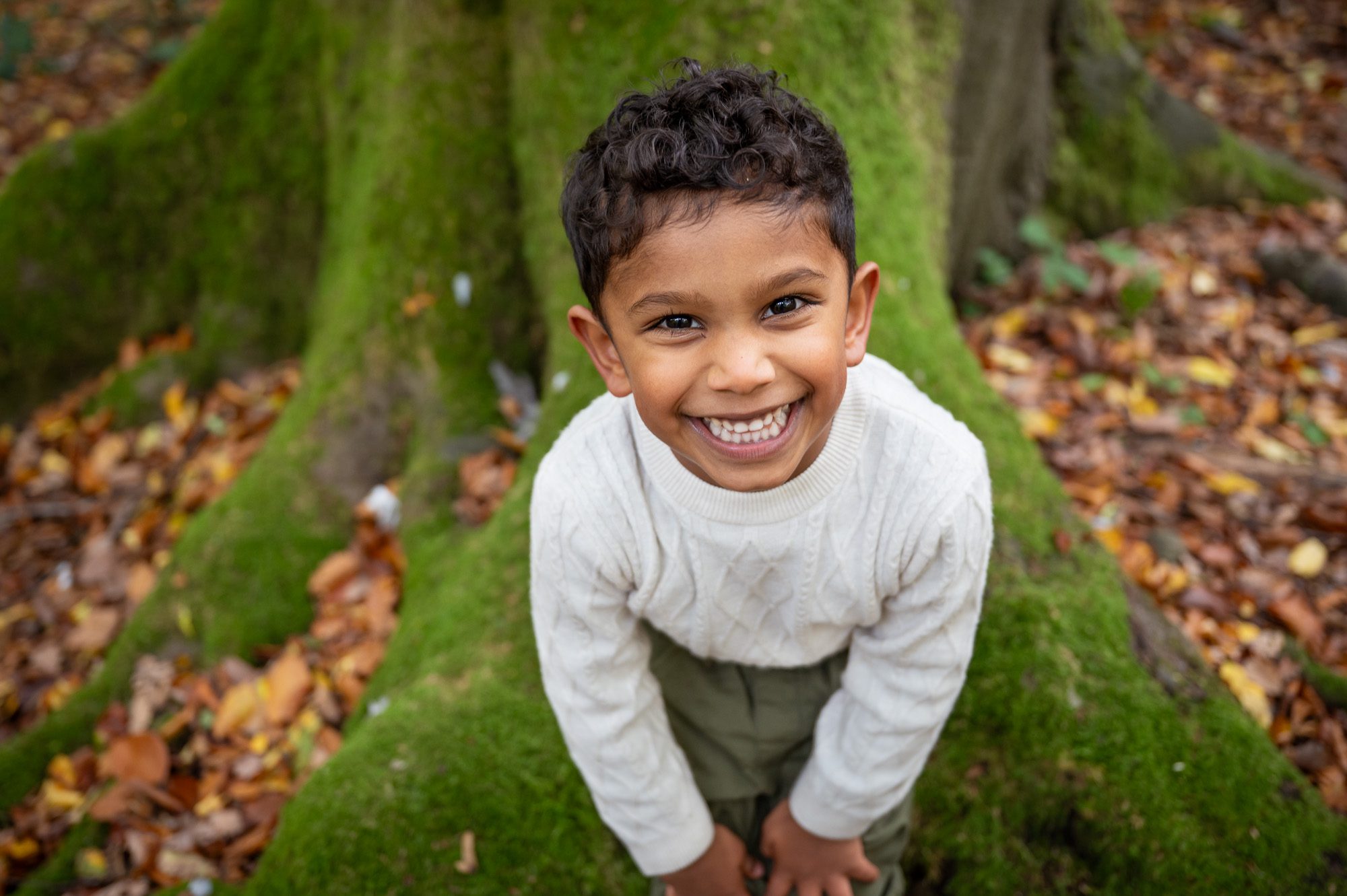 Boy grinning at camera in the forest