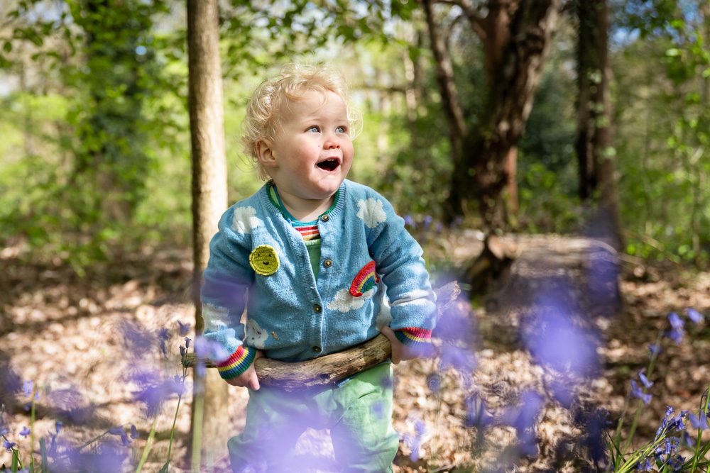 Toddler laughing in the bluebell woods